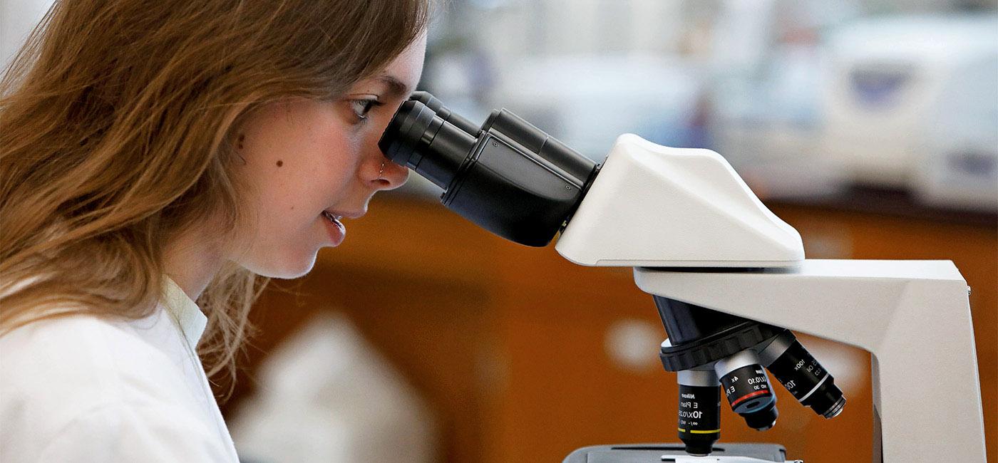 Female Student looking through Microscope